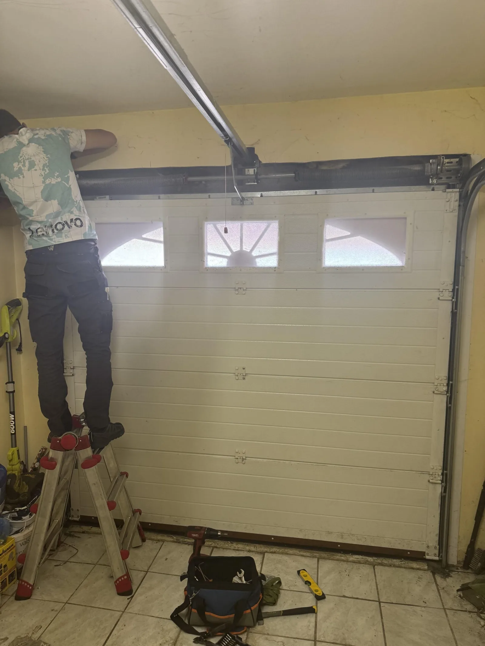Technicien en intervention sur une porte de garage à Ableiges