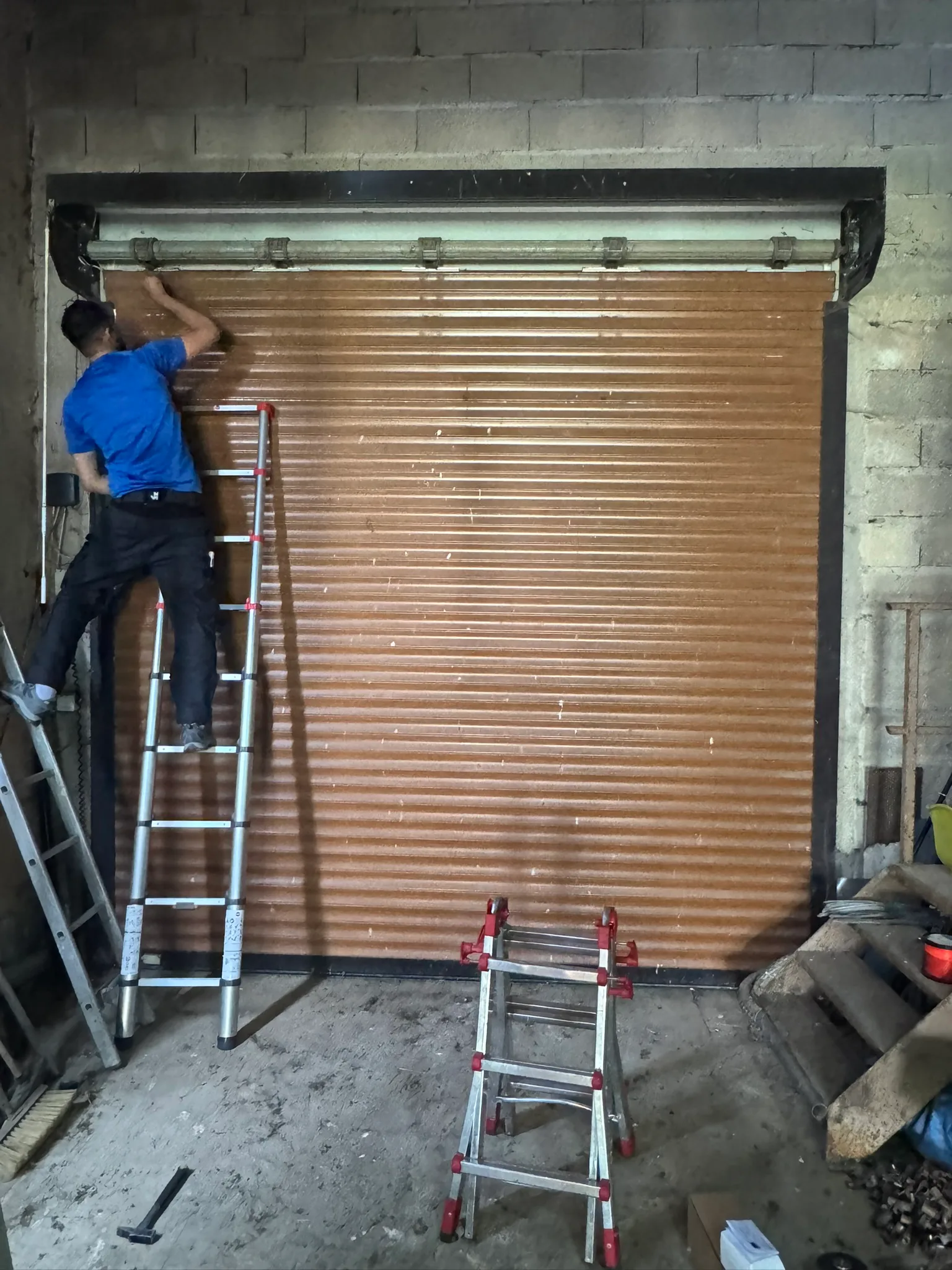 Technicien réparant une porte de garage enroulable