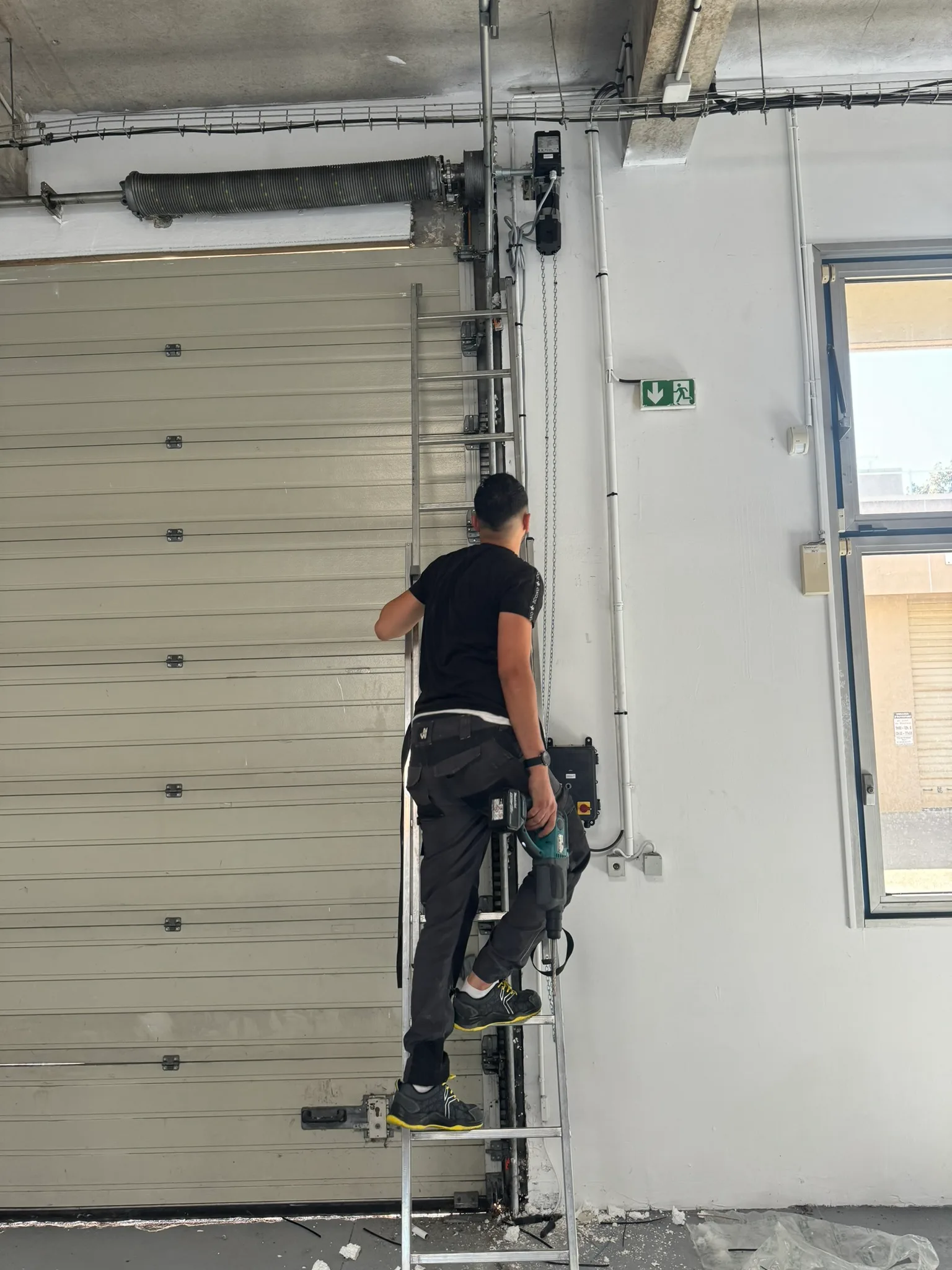 Technicien en intervention sur une porte de garage à Grenoble